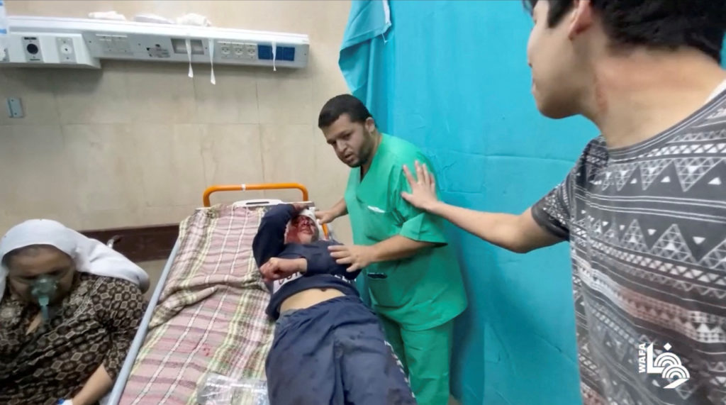 Injured people are assisted following what Wafa News Agency reports are air strikes by Israeli planes on a residential com...
