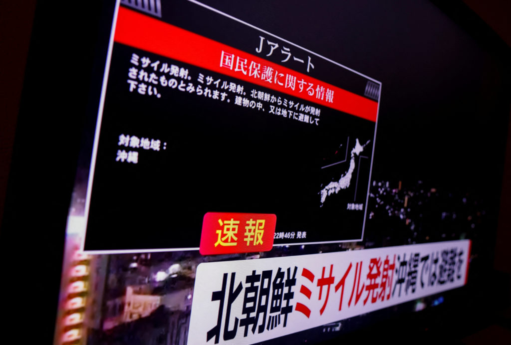 A TV screen displays a warning message called "J-alert" after the Japanese government issued an emergency warning, saying ...