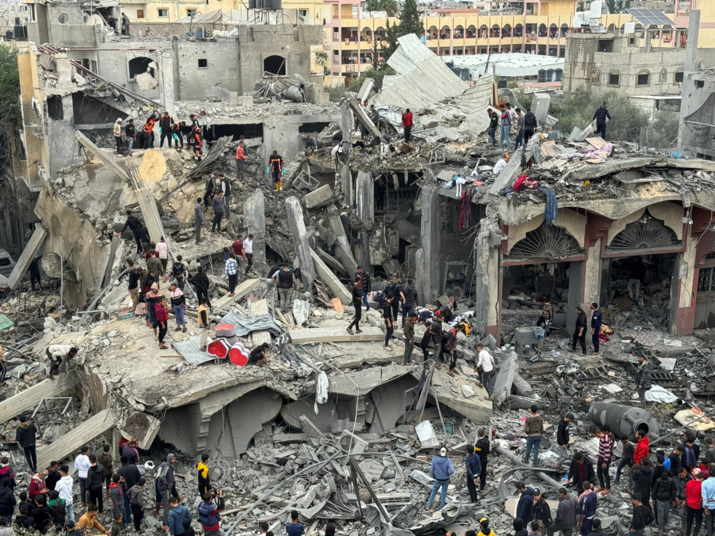Palestinians search for casualties at the site of Israeli strikes on a house in Rafah
