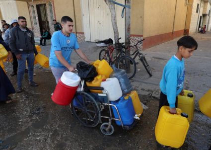 Palestinians wait to collect water, amid drinking water shortages, in Rafah