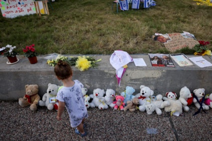 A child looks at an installation with pictures of hostages taken by Palestinian Islamist group Hamas, in Tel Aviv