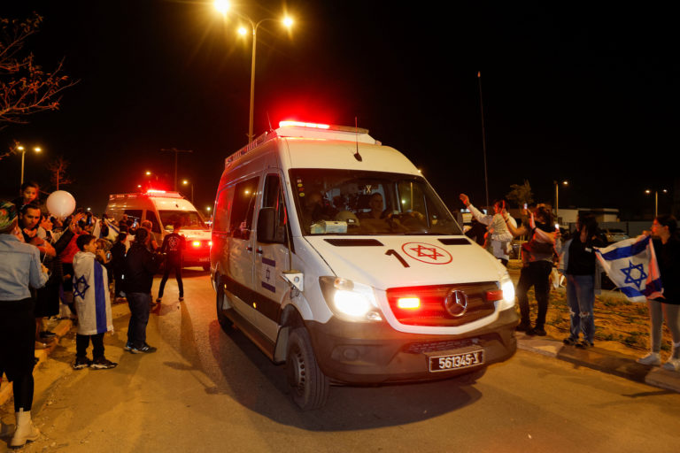 People react to the convoy carrying newly released hostages, in Ofakim