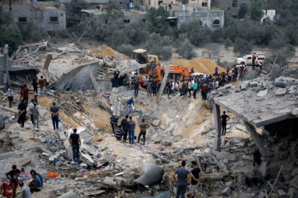 Palestinians gather at the site of an Israeli strike, in Khan Younis