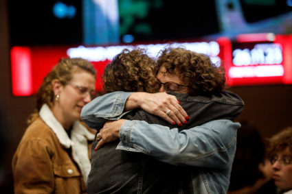 Members of the community of Kibbutz Kfar Aza react after people from their kibbutz community are released from the Gaza St...
