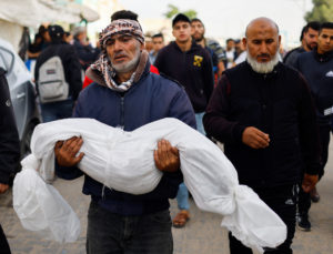 A man carries the body of a Palestinian child killed in Israeli strikes in Khan Younis