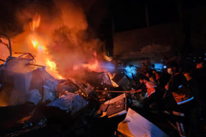 Palestinians try to put out a fire at the site of an Israeli strike on a house in Jabalia refugee camp on the northern Gaz...