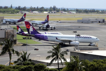 Hawaiian Airlines airplanes sit idle on the runway at the Daniel K. Inouye International Airport due to the business downt...