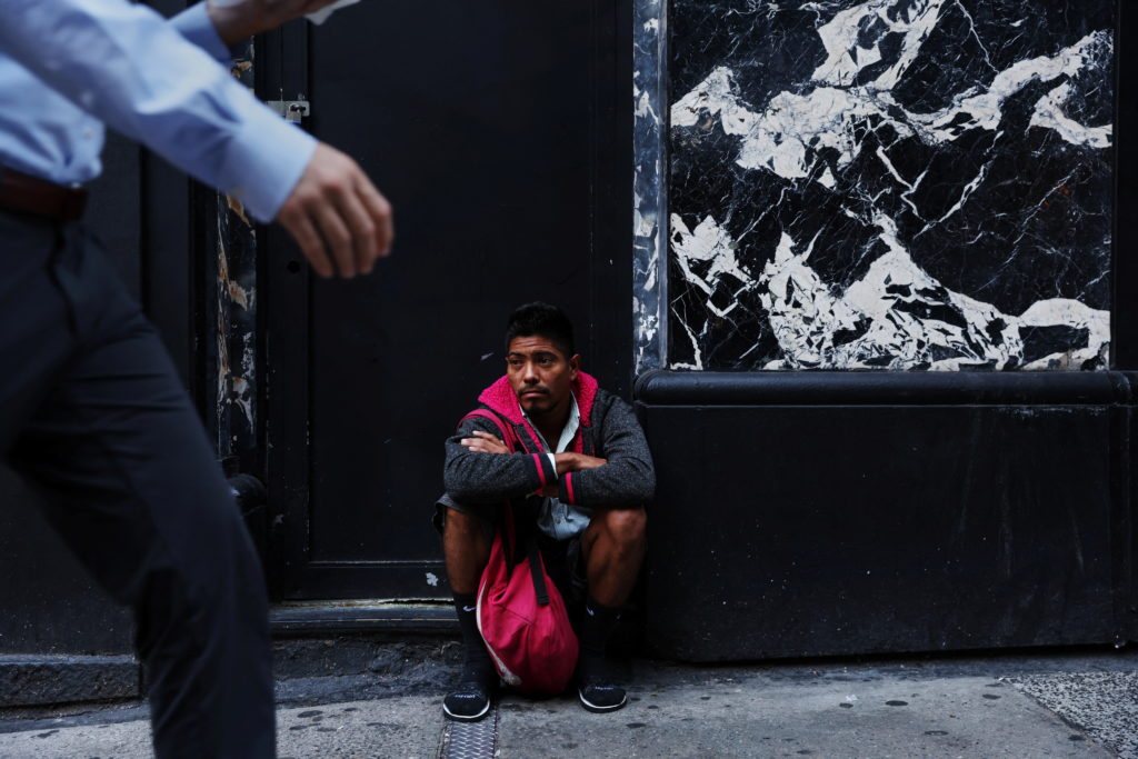 Jimmy Morales, who said he migrated from Honduras, sits outside the Roosevelt Hotel, which has acted as a makeshift shelte...