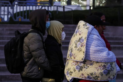 Immigrants stand waiting in line outside the Federal Plaza Immigration Court in New York City
