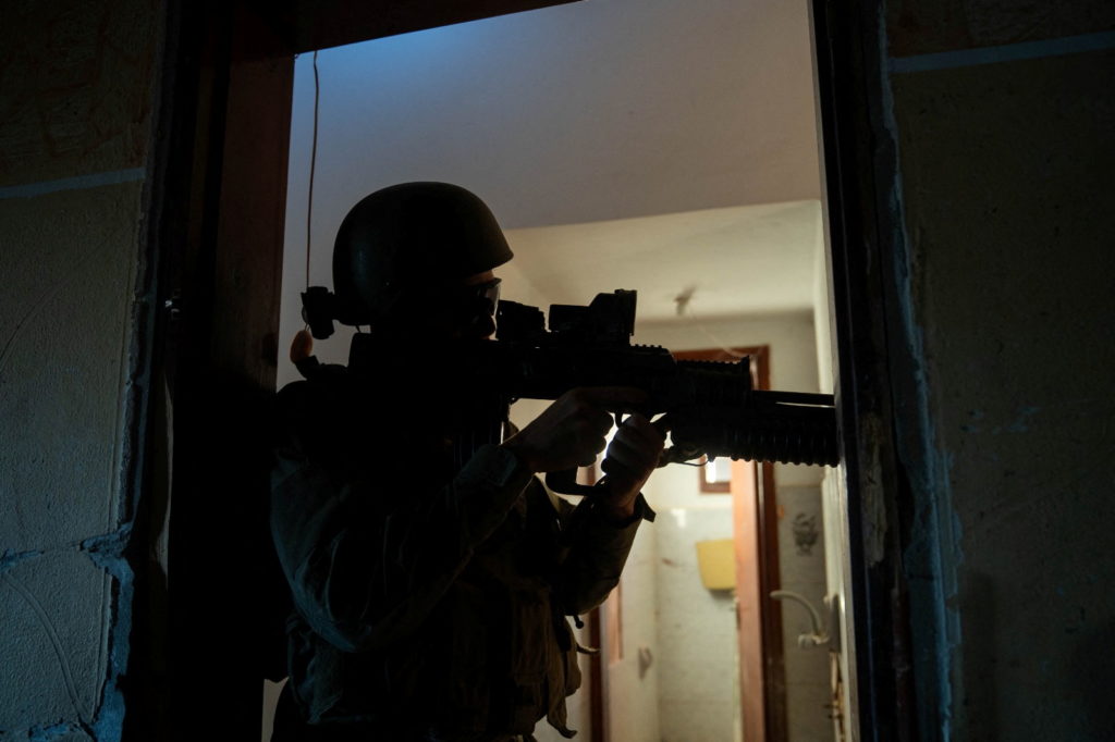 An Israeli soldier takes position during the ongoing ground operation of the Israeli army against Hamas, in the Gaza Strip...