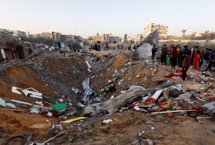 Palestinians search for casualties at the site of Israeli strikes on houses in Rafah
