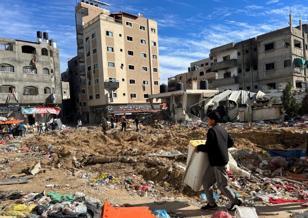 Palestinians inspect damages following an Israeli raid at Kamal Adwan hospital in the northern Gaza Strip