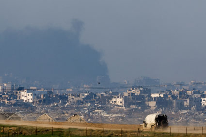 An Israeli military vehicle drives near damaged buildings in the Gaza Strip, amid the ongoing conflict between Israel and the Palestinian Islamist group Hamas, as seen from southern Israel, December 19, 2023. Photo by Clodagh Kilcoyne/REUTERS