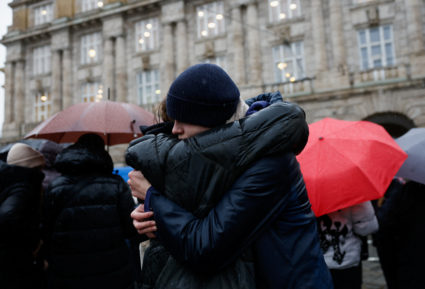 People observe a minute of silence in memory of the victims of the Charles University shooting, in Prague