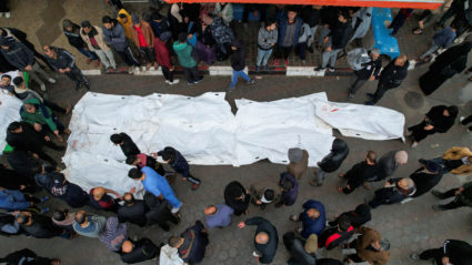 Mourners react next to the bodies of Palestinians killed in Israeli strikes at a hospital in the central Gaza Strip