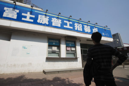 A job seeker looks at a closed job centre of Foxconn factory in the township of Longhua in Shenzhen
