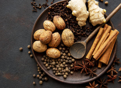 Gingerbread spices on slate - star anise, cinnamon, cloves, nutmeg, ginger, cardamom, black pepper