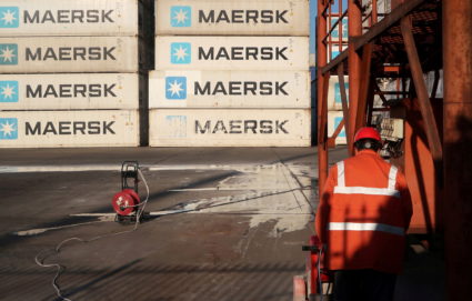 Worker is seen next to Maersk shipping containers at a logistics center near Tianjin por