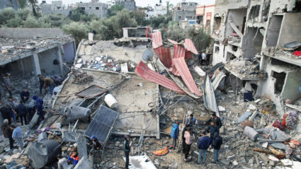 Palestinians gather at the site of Israeli strikes on houses, at the Maghazi camp in the central Gaza Strip