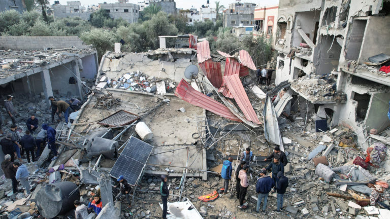 Palestinians gather at the site of Israeli strikes on houses, at the Maghazi camp in the central Gaza Strip