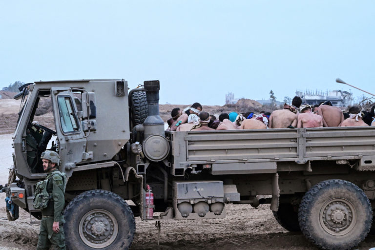 Israeli soldiers stand by truck with Palestinian detainees in the Gaza Strip