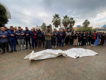 Mourners pray next to the bodies of Palestinians killed in Israeli strikes, at a hospital in the central Gaza Strip