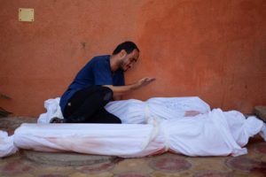 Palestinian man Mohammed al-Akhras reacts next to the bodies of his daughter Jana and his wife who were killed by Israeli ...