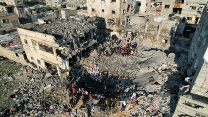 Palestinians gather at the site of an Israeli strike on a house, as the conflict between Israel and Hamas continues, in Rafah