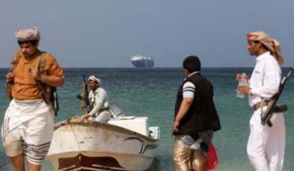 Armed men stand on the beach as the Galaxy Leader commercial ship, seized by Yemen's Houthis last month, is anchored off the coast of al-Salif, Yemen, December 5, 2023. Photo by Khaled Abdullah/REUTERS
