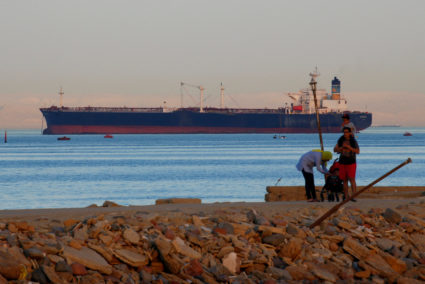 People walk on the beach as a container ship crosses the Gulf of Suez towards the Red Sea before entering the Suez Canal, in El Ain El Sokhna in Suez, east of Cairo, Egypt April 24, 2017. Picture taken April 24, 2017. Photo by Amr Abdallah Dalsh/REUTERS