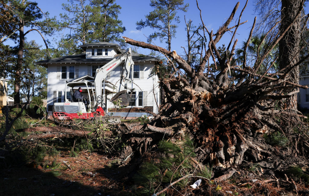 A worker removes fallen trees from the yard of a home a day after a tornado struck the town of Bamberg, South Carolina, U.S. January 10, 2024. Photo by Sam Wolfe/REUTERS