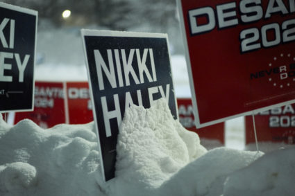 A view of campaign signs in the snow near the venue, on the day of the Republican presidential debate hosted by CNN at Drake University in Des Moines, Iowa, U.S. January 10, 2024. Photo by Cheney Orr/REUTERS
