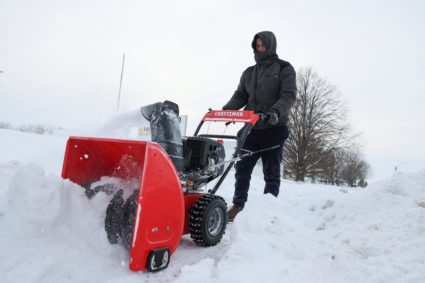 A maintenance worker removes snow from a sidewalk, ahead of Iowa state caucus vote, in West Des Moines, Iowa, U.S. January 15, 2024. Photo by Brendan McDermid/REUTERS