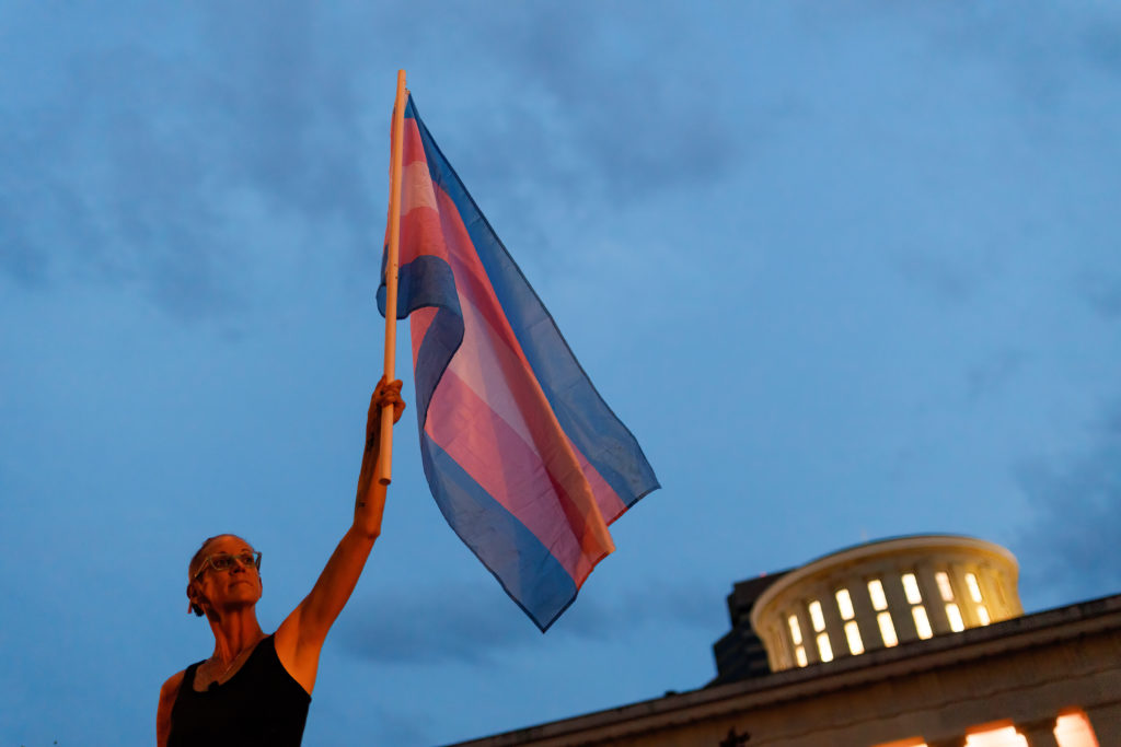 Cole Ramsey, 39, of South Linden holds a Transgender Pride Flag in front of the Ohio Statehouse to protest the passing of ...