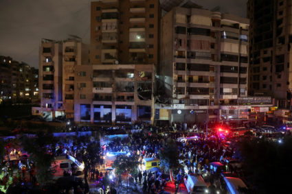 People gather near a damaged site following an explosion at Beirut suburb of Dahiyeh