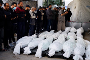 Mourners react next to the bodies of Palestinians killed in an Israeli strike, in Rafah