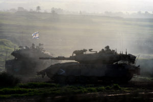 Israeli soldiers ride military vehicles while moving out of Gaza Strip, as seen from southern Israel