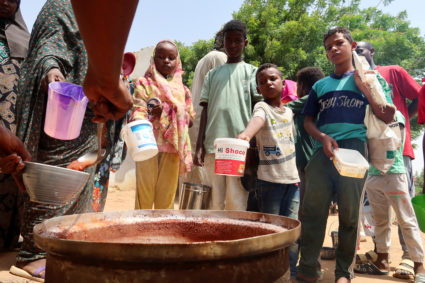 FILE PHOTO: People hold pots as volunteers distribute food in Omdurman, Sudan, September 3, 2023. Photo by El Tayeb Siddig/Reuters