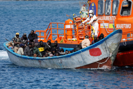 Migrants wait to disembark from a fiber boat after being rescued by a Spanish coast guard vessel in the port of Arguineguin