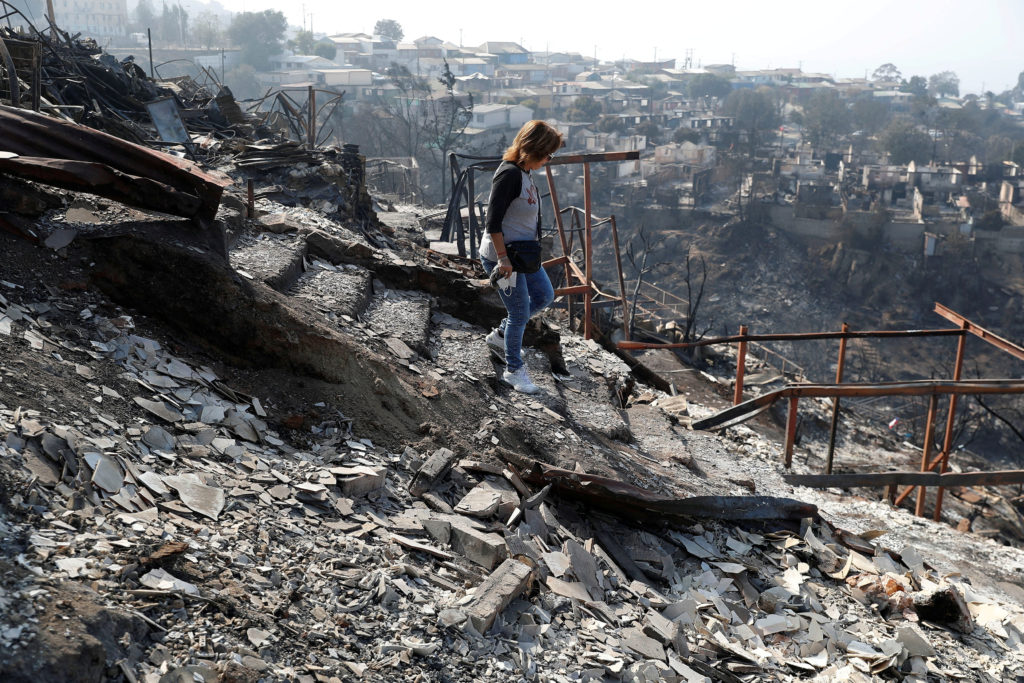 Ingrid Crespo walks on the remains of her house burned, following the spread of wildfires in Vina del Mar, Chile February ...
