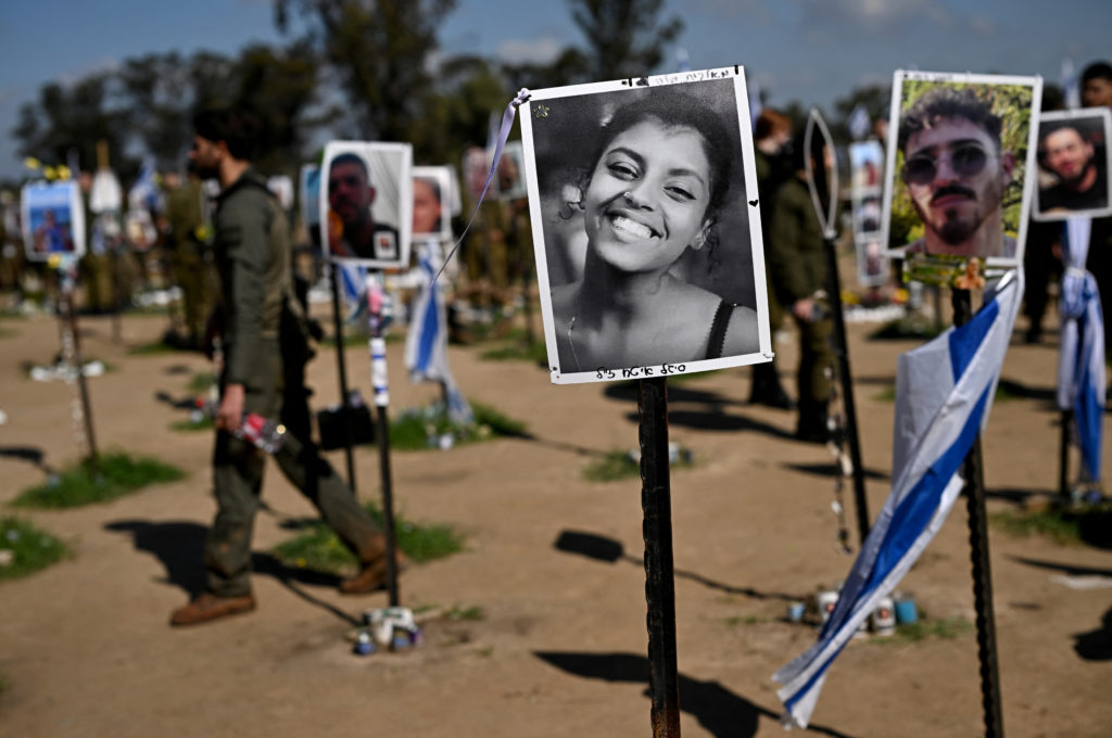 Soldiers visit the site of the Nova festival, with displayed photos of the people who were killed and kidnapped during the...