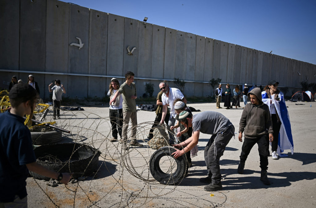 People prepare a road blockade as they protest against the delivery of humanitarian aid to Gaza.
