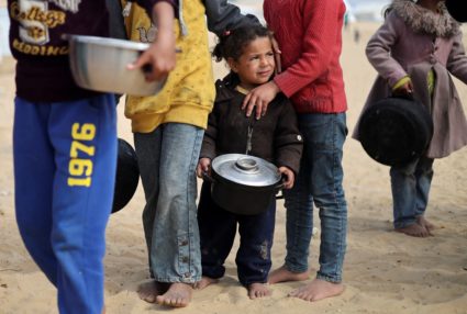 Displaced Palestinian children wait to receive free food at a tent camp, amid food shortages, in Rafah