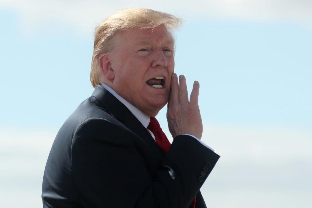 U.S. President Trump shouts an answer to a reporter’s question on the tarmac after arriving aboard Air Force One during a ...