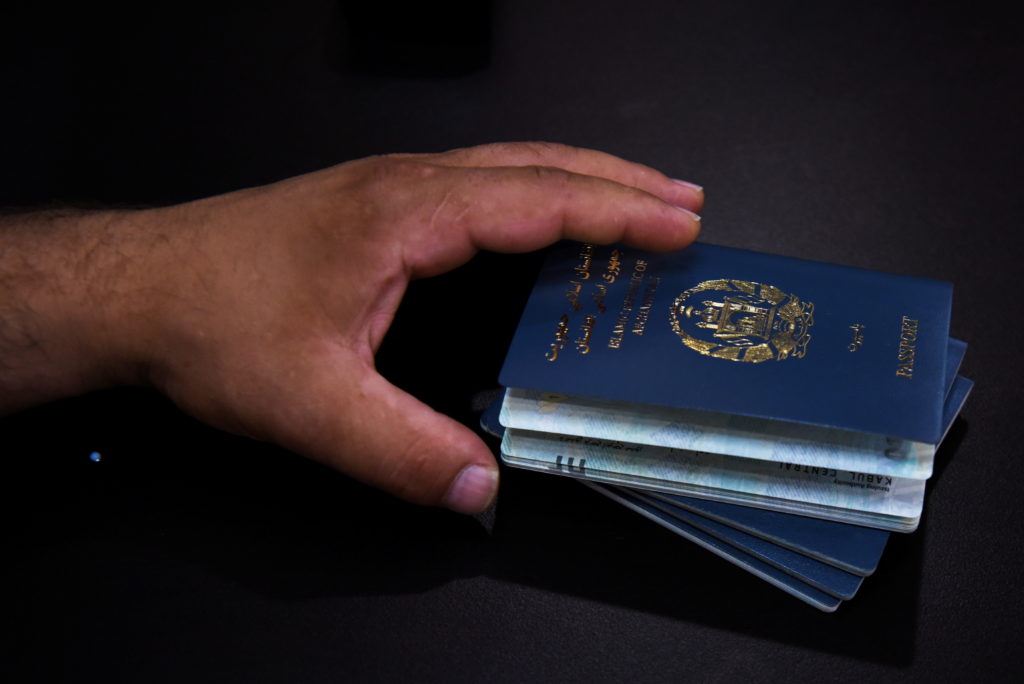 FILE PHOTO: Afghan Abdul Aman Sediqi, a U.S. Special Immigrant Visa (SIV) recipient, holds his family’s passports as they ...