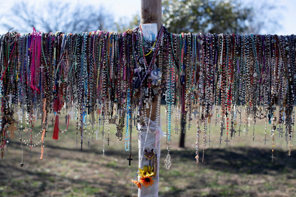 Dozens of rosaries hang over a memorial cross in front of Robb Elementary School, as U.S. Attorney General Merrick Garland announces the results of a review into the law enforcement response to a 2022 mass shooting in Uvalde, Texas, U.S., January 18, 2024. Photo by Kaylee Greenlee Beal/Reuters