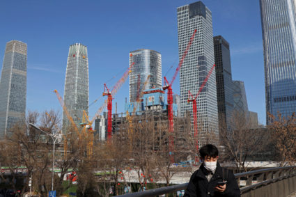 A man walks past a construction site and skyscrapers at the central business district (CBD) during morning rush hour, ahead of the opening of the National People's Congress (NPC), in Beijing, China, February 29, 2024. Photo by Florence Lo/Reuters