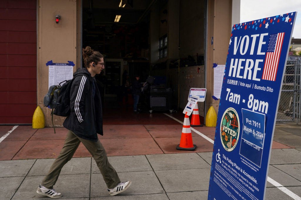 A person walks past a polling place set up inside a fire station during the Super Tuesday primary election in San Francisc...