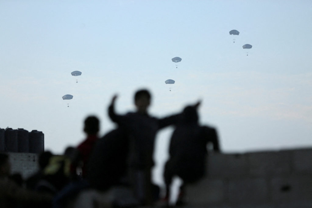 FILE PHOTO: People watch as U.S. military carries out its first aid drop over Gaza, amid the ongoing the conflict between ...