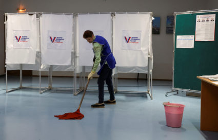A cleaner mops the floor near voting booths at a polling station during preparations for the presidential election, in the town of Novaya Ladoga in the Leningrad region, Russia, March 14, 2024. Photo by Anton Vaganov/Reuters